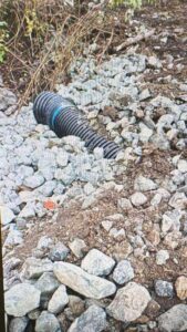 culvert-outlet A drainage culvert pipe exit surrounded by heavy stones to prevent soil washout during heavy rain.