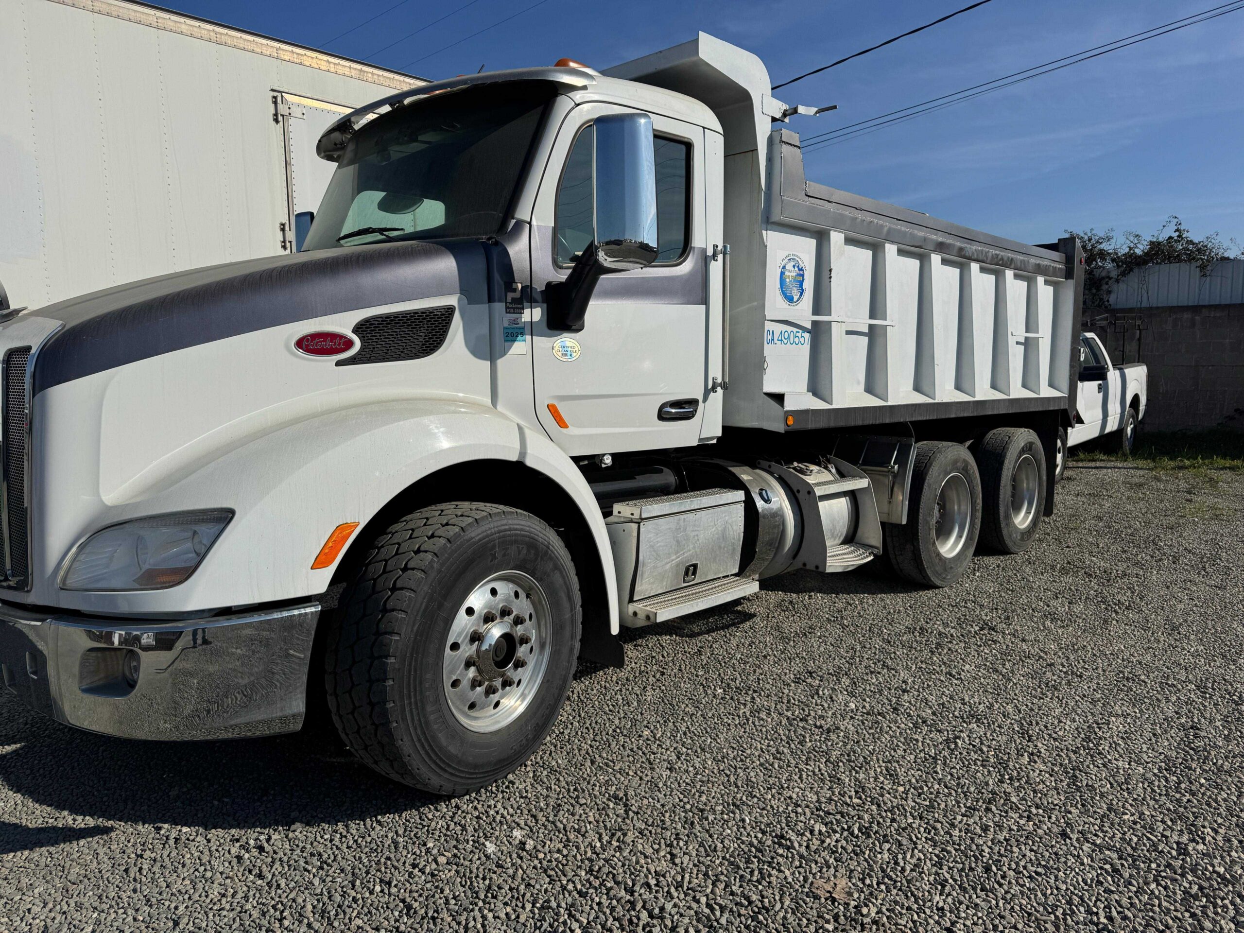 Heavy Duty Construction Material Hauling Large white heavy-duty Peterbilt dump truck with a white dump bed parked on a gravel job site.