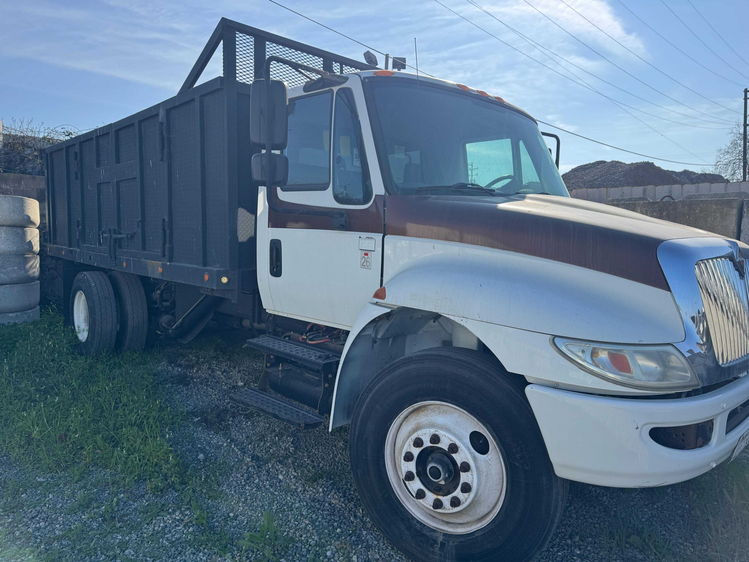 High Volume Site Debris Removal Truck High-capacity white commercial vocational truck featuring a tall black utility dump box container.